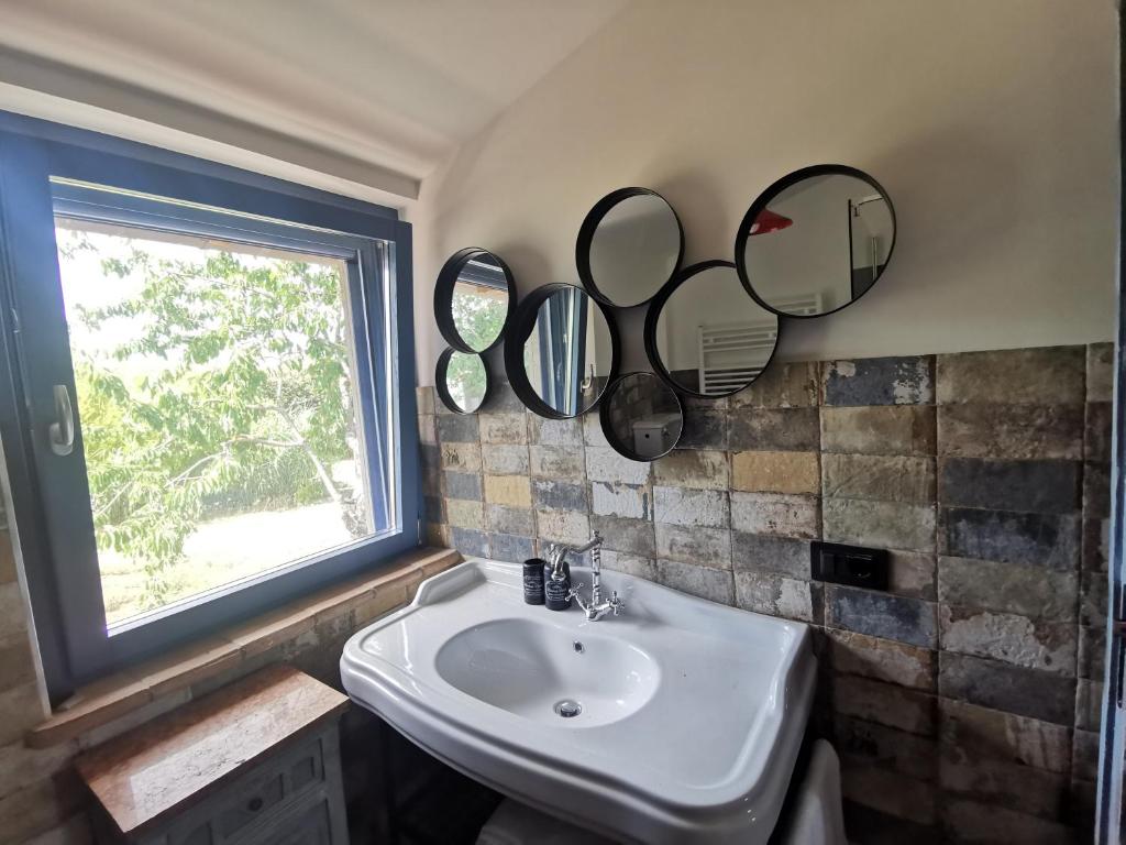 une salle de bain avec un lavabo et des miroirs au mur dans l'établissement Domus Nirale, à Bagnoregio 19 autres photos