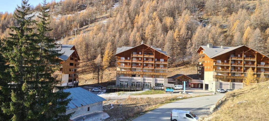un groupe de bâtiments avec une montagne en arrière-plan dans l'établissement le Soleil des Neiges, à La Foux