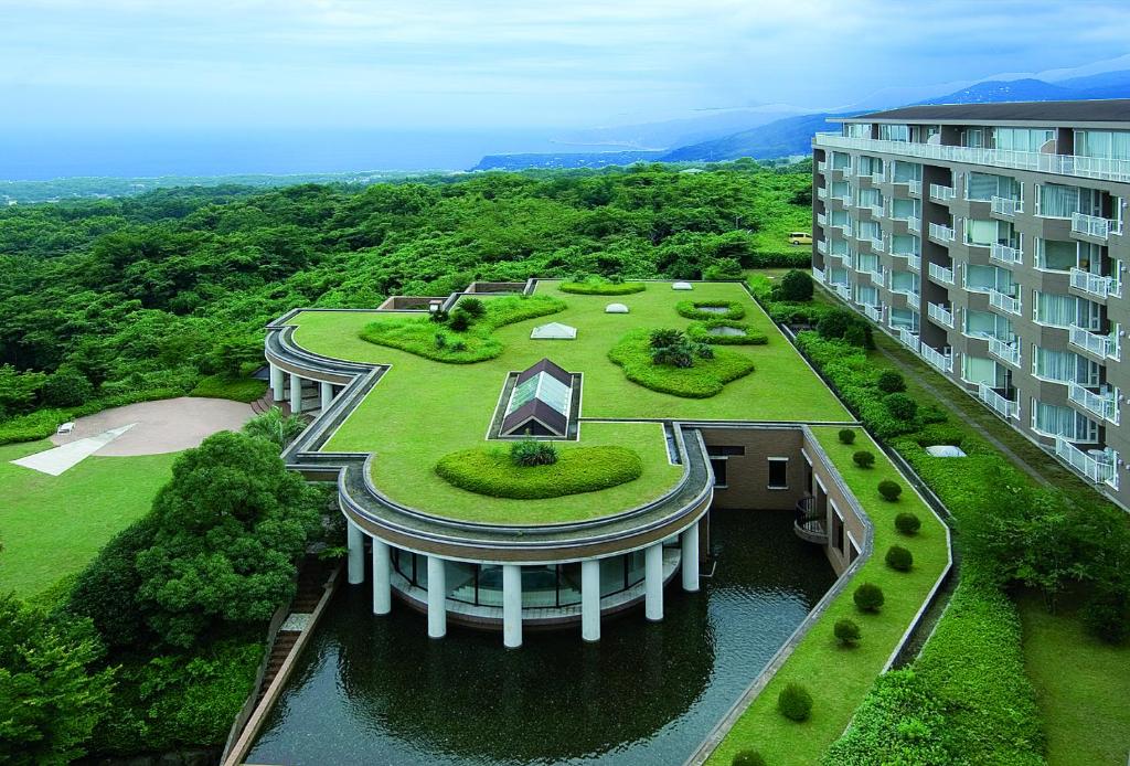 un bâtiment avec un jardin en haut dans l'établissement Hotel Village Izukogen, à Itō