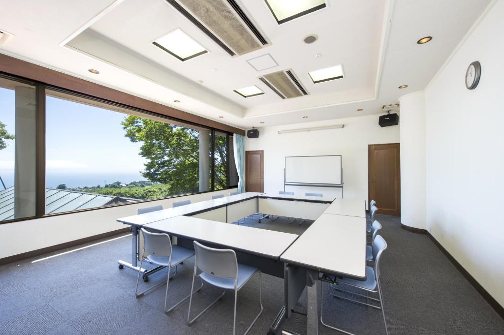 un bureau avec une table, des chaises et une grande fenêtre dans l'établissement Hotel Village Izukogen, à Itō 110 autres photos