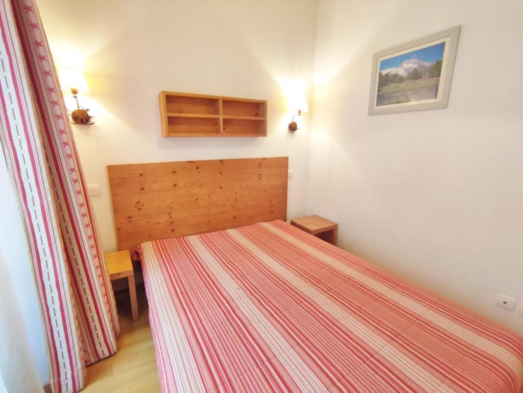 Cette petite chambre comprend un lit avec un couvre-lit rayé. dans l'établissement Ostal, T3, centre Luchon, wifi, casier à skis, ascenseur, 6 personnes, à Luchon