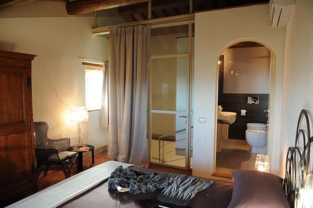 un salon avec un canapé et une salle de bains. dans l'établissement VILLA LARINO Luxury villa in Tuscany with breathtaking view, à Forcoli