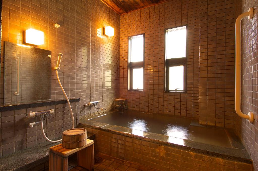une salle de bain avec une baignoire et un lavabo dans l'établissement Ichinoyu Katei, à Yamanouchi