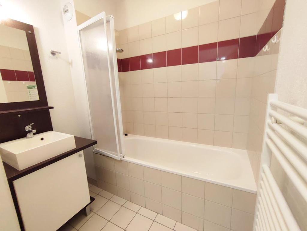 une salle de bain avec un lavabo, une baignoire et des toilettes dans l'établissement Evasion, T3, centre Luchon, wifi, casier à skis, ascenseur, 6 personnes, à Luchon