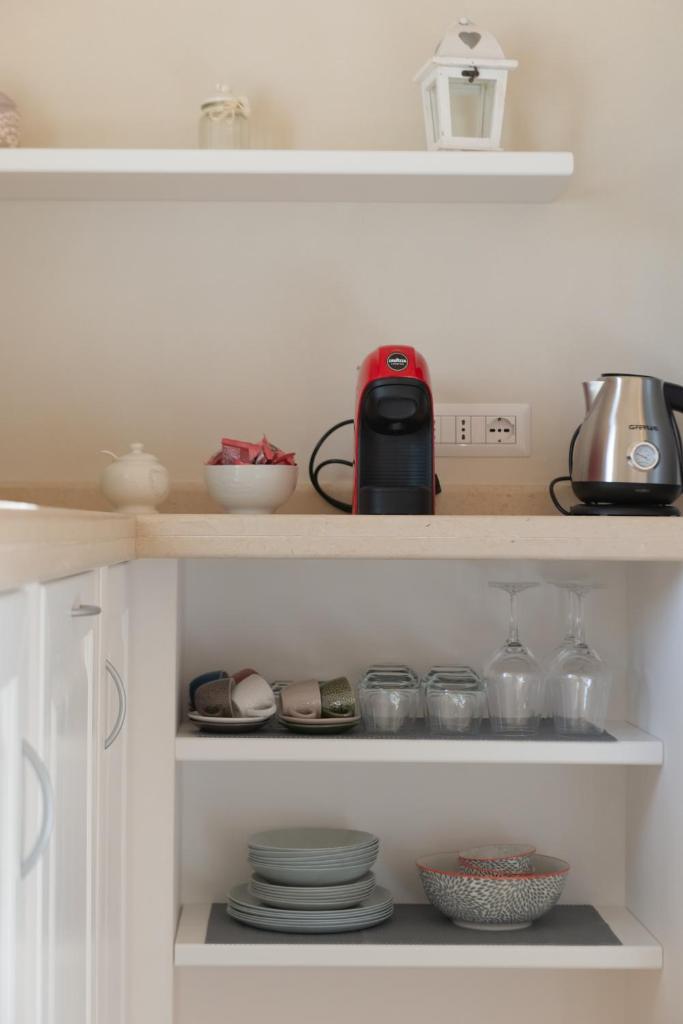 - une étagère de cuisine avec de la vaisselle et un grille-pain dans l'établissement Trullo Mamamè, à Cisternino 75 autres photos