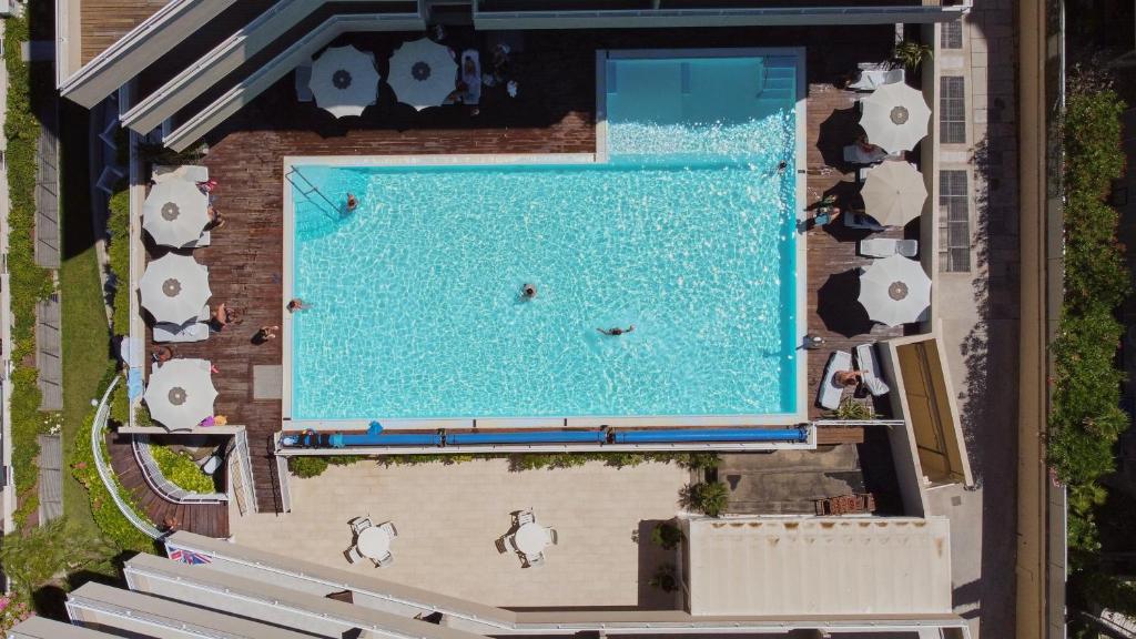 une vue aérienne d'une piscine dans un complexe hôtelier dans l'établissement Bellettini Hotel, à Milano Marittima