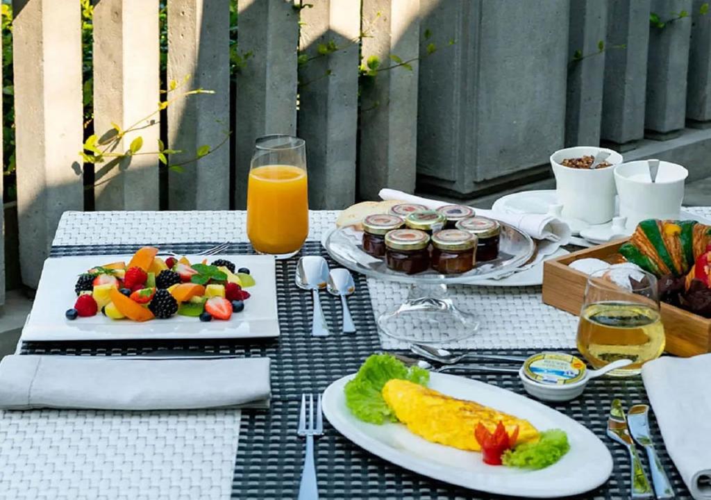 une table avec des assiettes de nourriture et un verre de jus d'orange dans l'établissement Villa Lario Resort Mandello, à Mandello del Lario