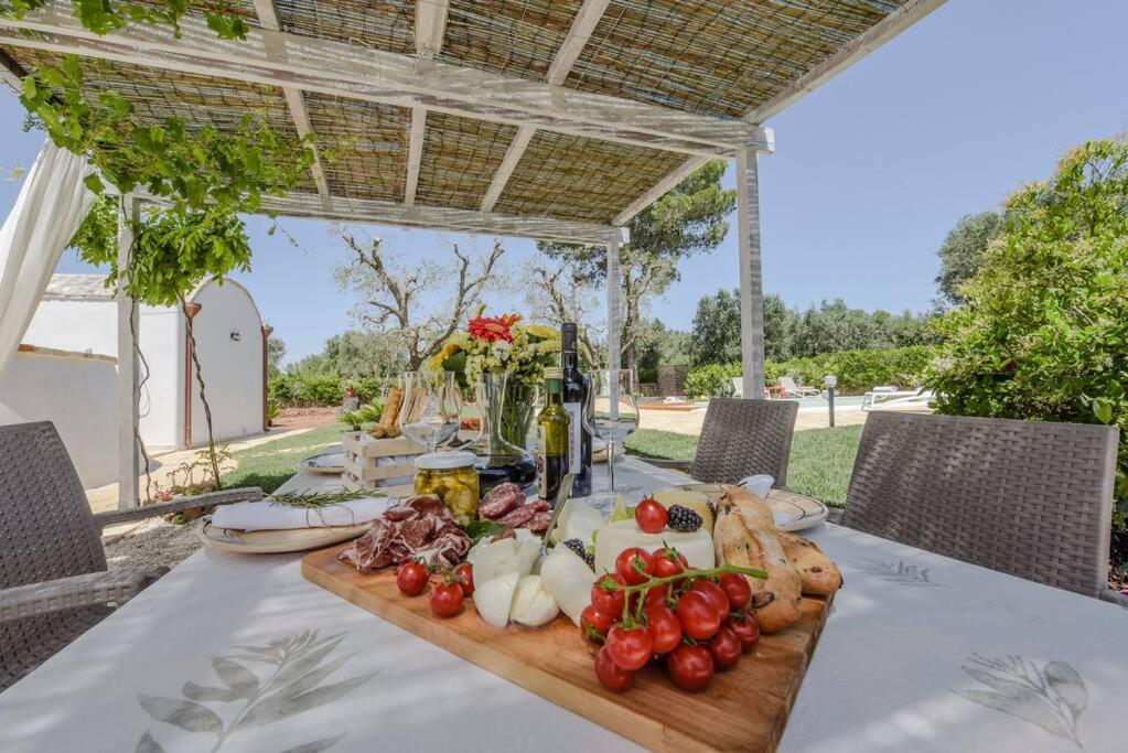une table avec des légumes sur une planche à découper en bois dans l'établissement TRULLO CHEFMARCO PRIVATE/SALTWATER SWIMMING POOL, à San Michele Salentino