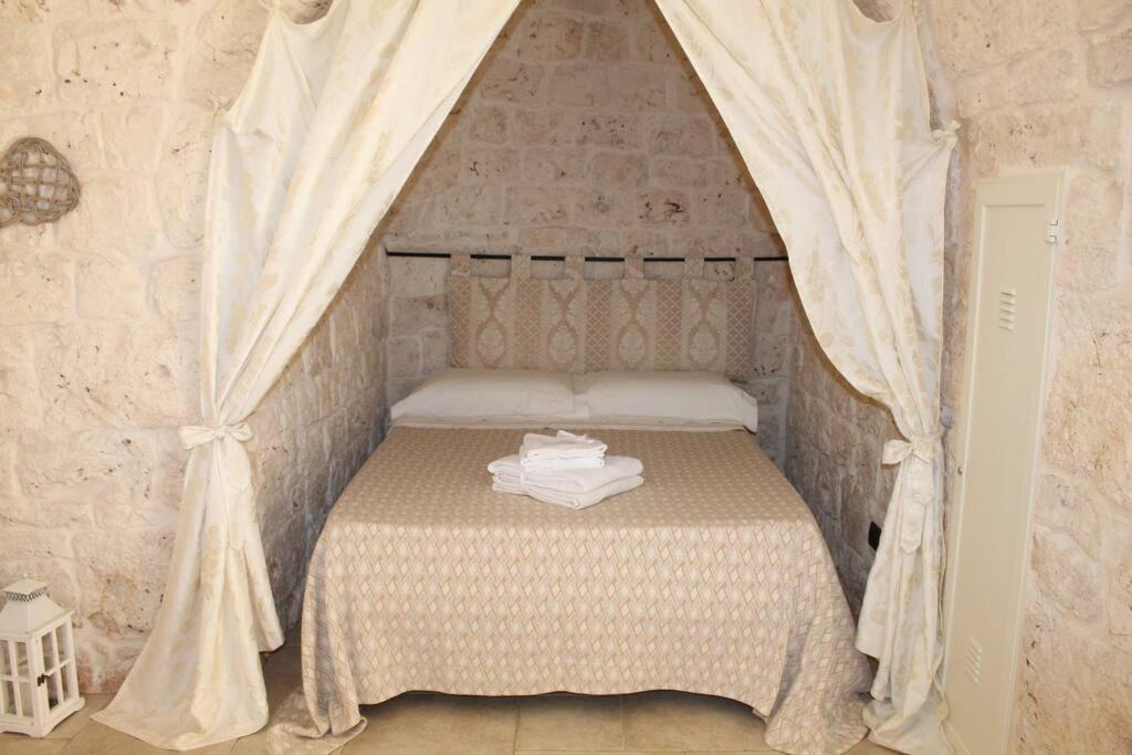 - une petite chambre avec un lit à baldaquin dans l'établissement TRULLO CHEFMARCO PRIVATE/SALTWATER SWIMMING POOL, à San Michele Salentino