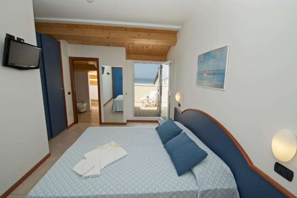 une chambre avec un lit bleu et une télévision dans l'établissement Hotel Torretta, à Cattolica 79 autres photos