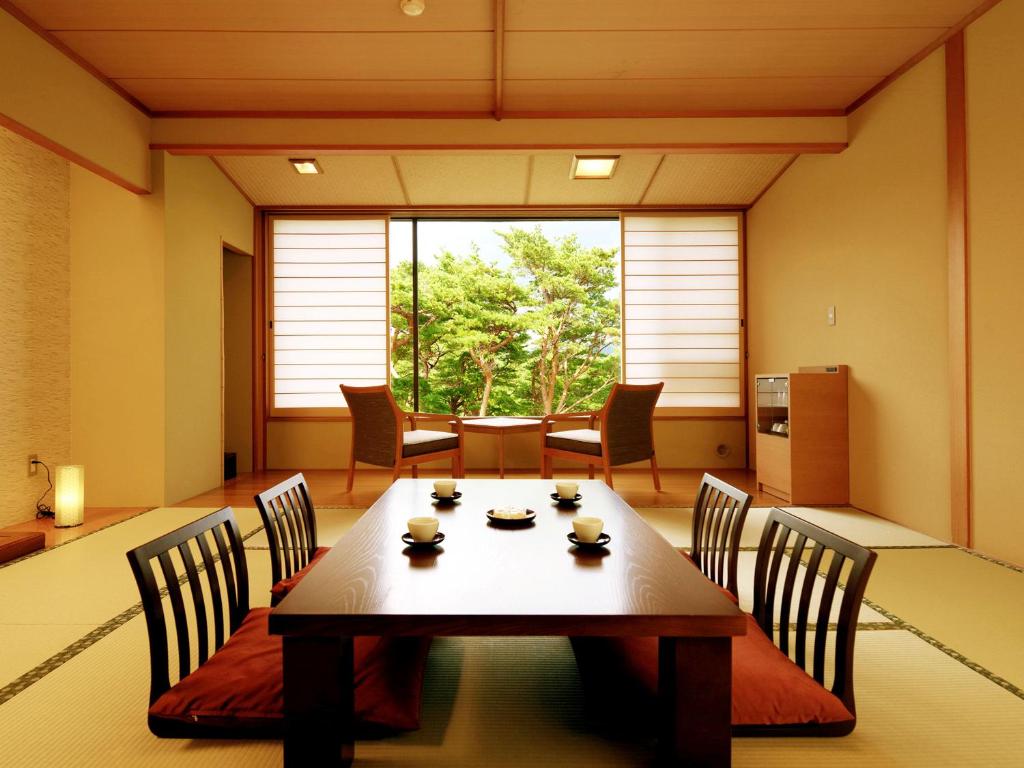 une salle à manger avec une table et des chaises et une grande fenêtre dans l'établissement Jodogahama Park Hotel, à Miyako 11 autres photos