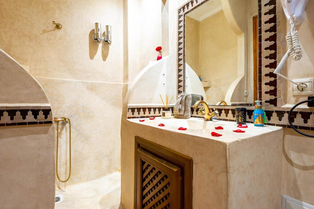 une salle de bain avec un lavabo et une douche dans l'établissement Riad La Croix Berbere Deluxe, à Marrakech