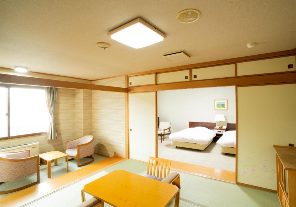 une chambre avec un lit, une table et des chaises dans l'établissement Oehonke, à Kitami 36 autres photos