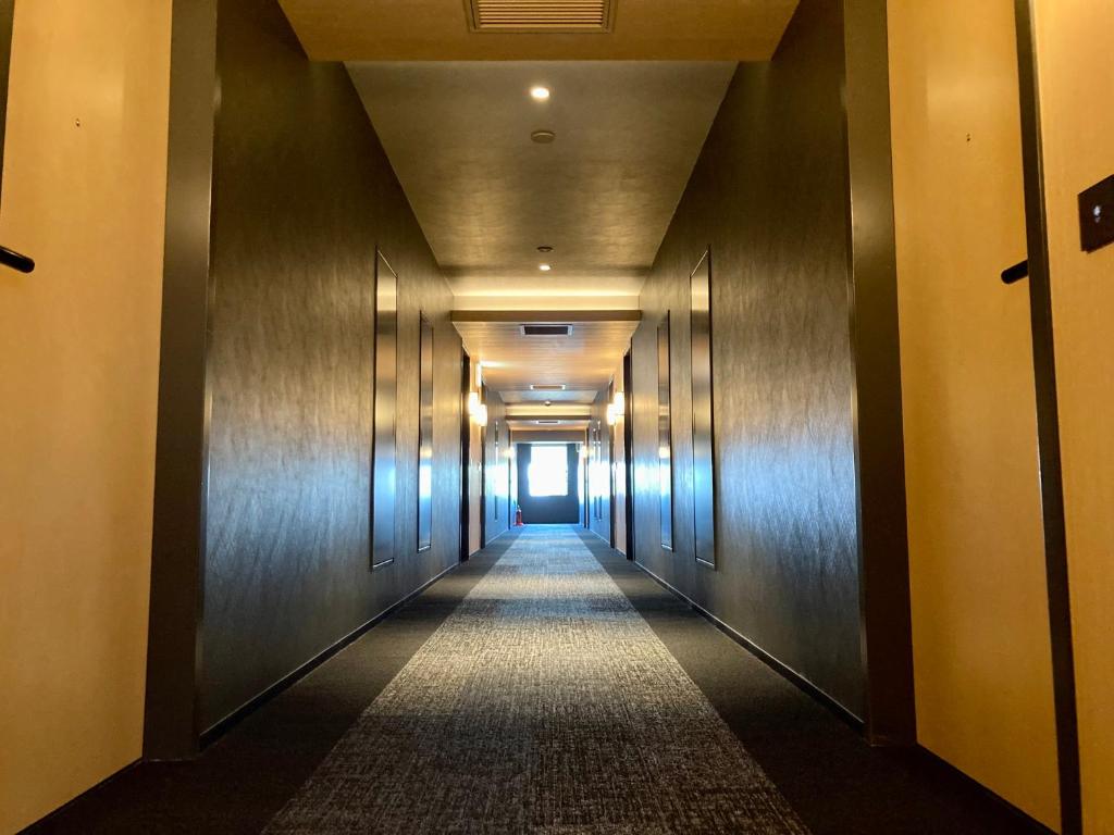 un couloir d'un immeuble avec un long couloir dans l'établissement Urakusatsu TOU, à Kusatsu