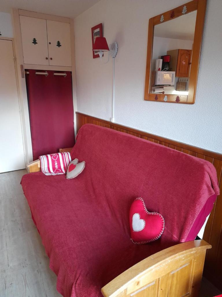 - un canapé avec une couverture rouge dans l'établissement Samoëns studio, à Samoëns