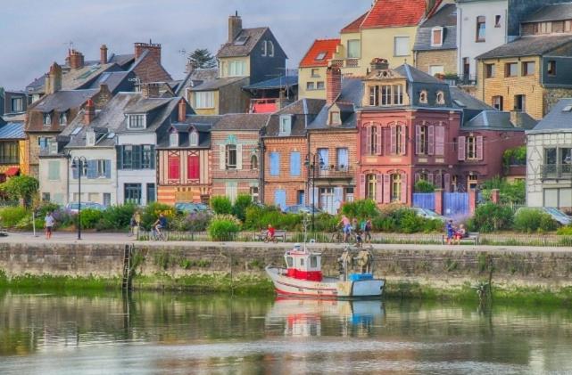 un bateau dans l'eau devant un groupe de maisons dans l'établissement le mobile home Le Victory situé au Camping Le Rio, à Noyelles-sur-Mer