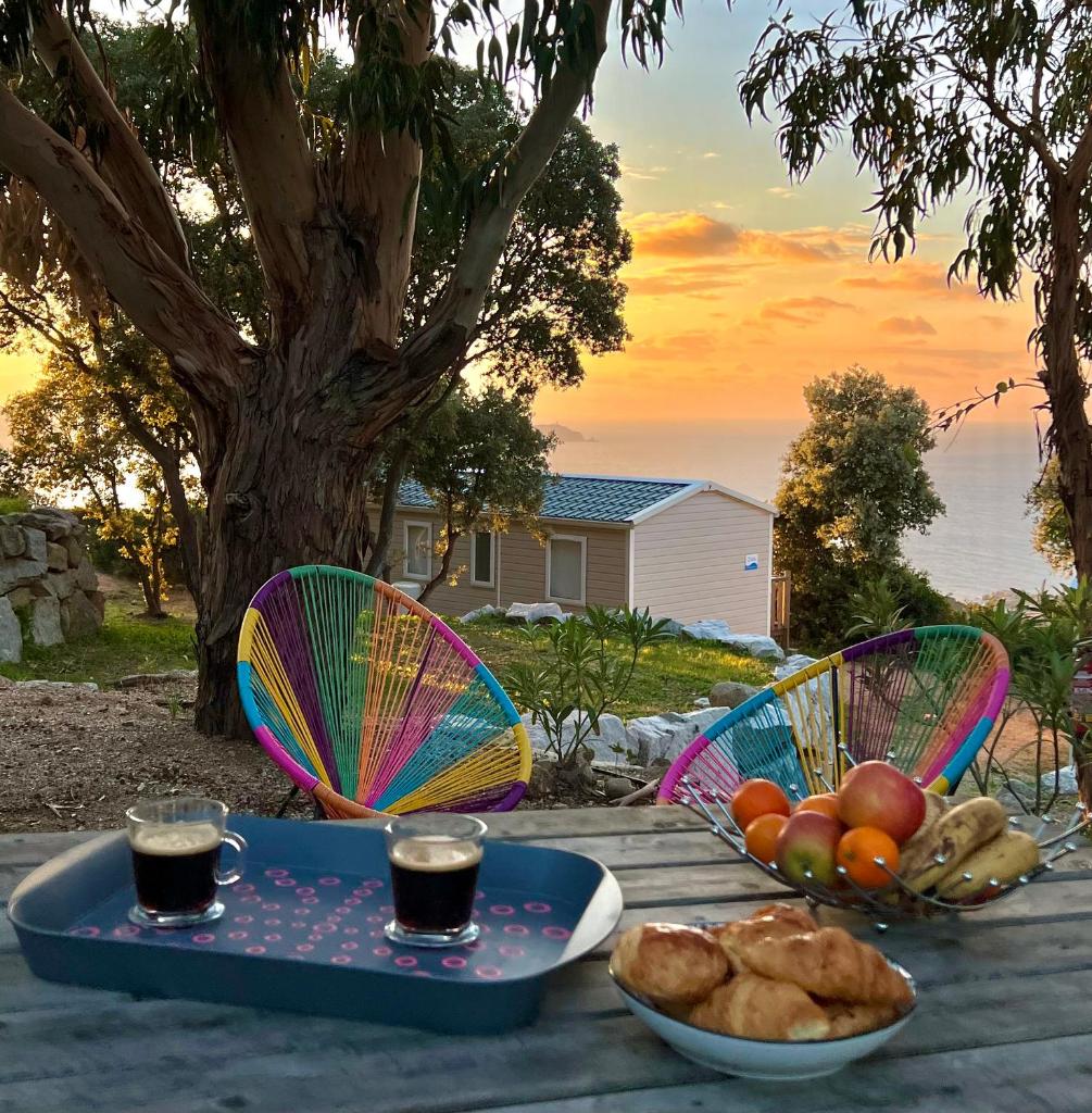 - une table avec deux assiettes de nourriture et deux boissons dans l'établissement Piana, à Lumio 13 autres photos
