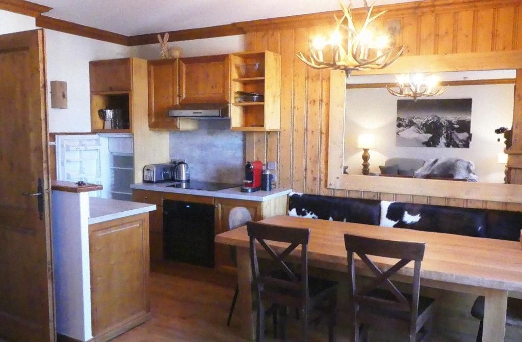une cuisine avec une table en bois et une salle à manger dans l'établissement Chalet Mont Blanc - Arc 1950 - Ski-in Ski-out, 2 bed duplex, sleeps 8, à Bourg-Saint-Maurice