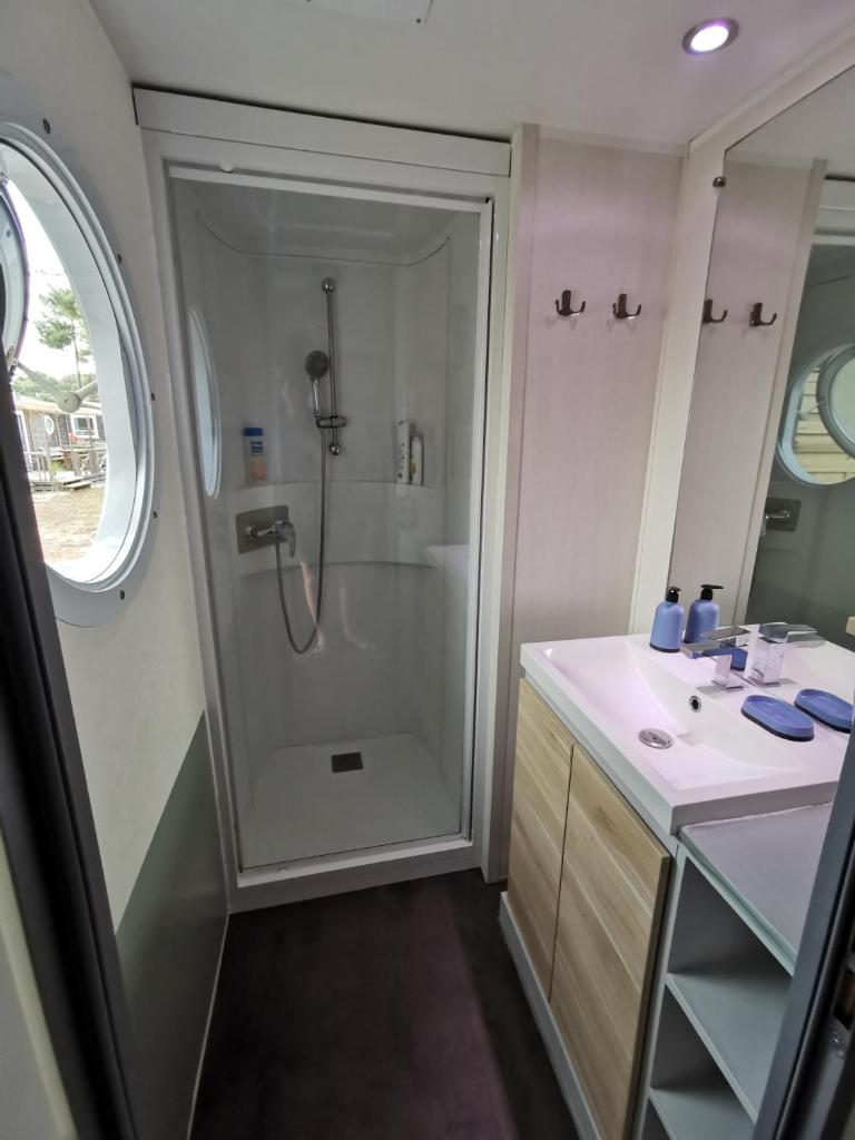 une salle de bain avec douche et lavabo dans l'établissement Mobil home 6 Personnes au Atlantic Club Montalivet, à Vendays-Montalivet 23 autres photos