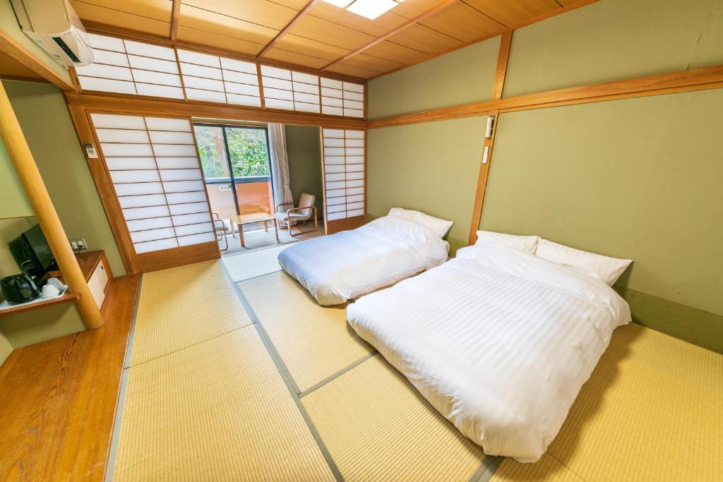 - une chambre avec 2 lits blancs dans l'établissement Kozuka Hisanoha, à Hakone