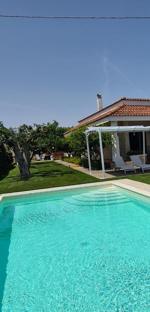 une grande piscine bleue devant une maison dans l'établissement Villa Brancasi con piscina, à Brindisi