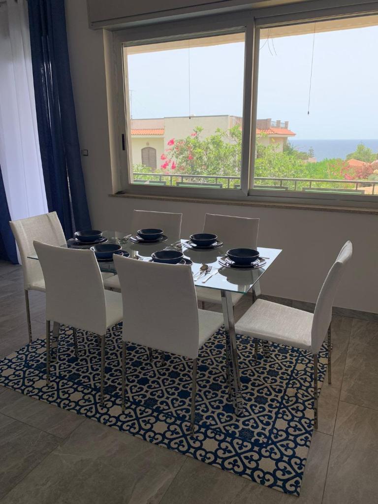 une salle à manger avec une table et des chaises et une fenêtre dans l'établissement LA PERLA BLU DI FONTANE BIANCHE, à Fontane Bianche