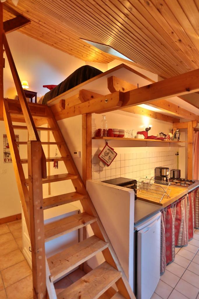 une cuisine avec un escalier en bois dans l'établissement Hôtel Restaurant Gîtes Les 5 Saisons, à Freissinières