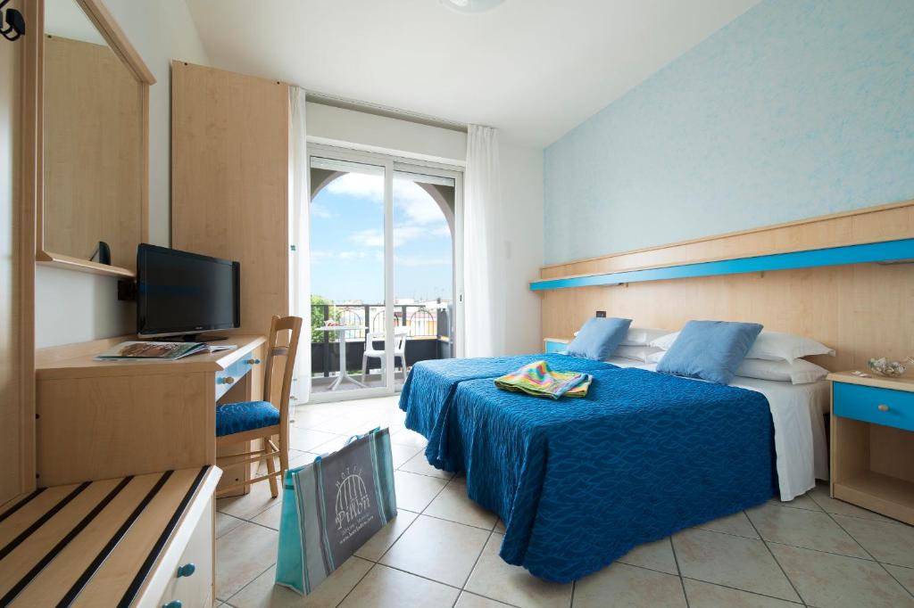 une chambre d'hôtel avec deux lits et une télévision dans l'établissement Hotel Pillon, à Bibione