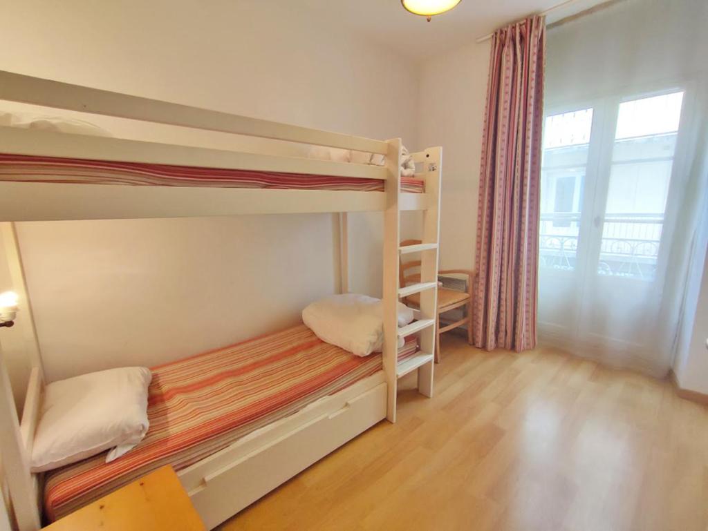 une chambre avec deux lits superposés et une fenêtre dans l'établissement Zénitude, T3, centre Luchon, wifi, casier à skis, ascenseur, 6 personnes, à Luchon