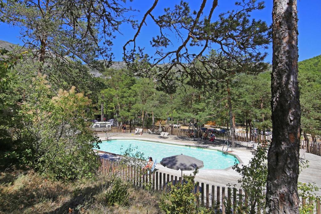 une piscine dans une cour clôturée dans l'établissement Huttopia Gorges du Verdon, à Castellane