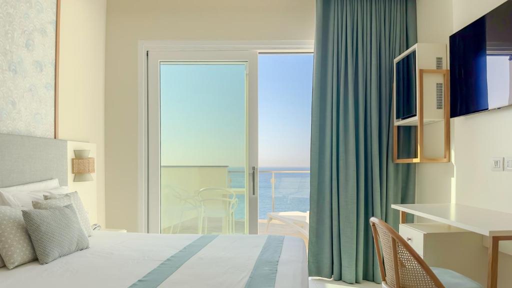 une chambre avec un lit et une vue sur l'océan dans l'établissement Hotel Giosue' a mare Sorrento, à Meta