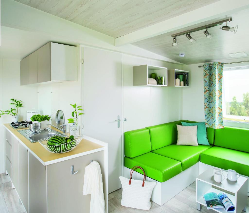 - un canapé vert dans la salle de bains pourvue d'un lavabo dans l'établissement Camping le Rancho, à Argelès-sur-Mer