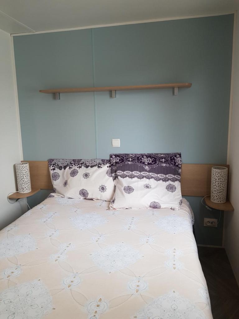une chambre avec un lit avec deux oreillers dans l'établissement Mobil home MAXI CONFORT SUR LA COTE D'AZUR, à Fréjus