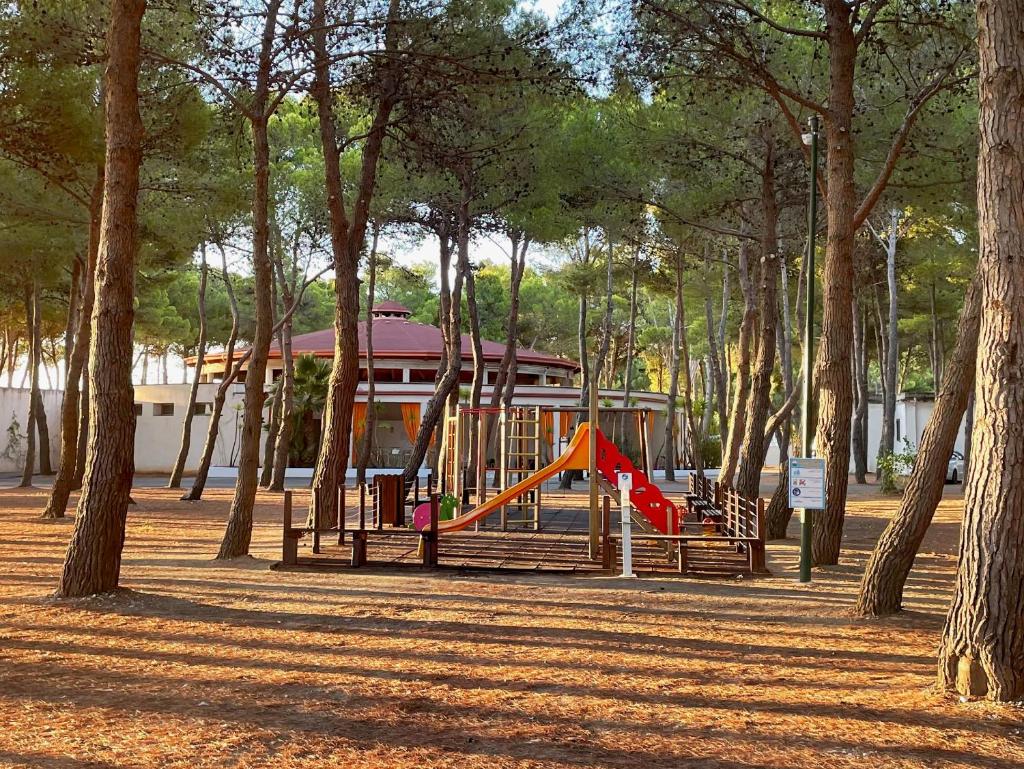 une aire de jeux avec un toboggan dans un parc arboré dans l'établissement Hotel Portonuovo, à Vieste