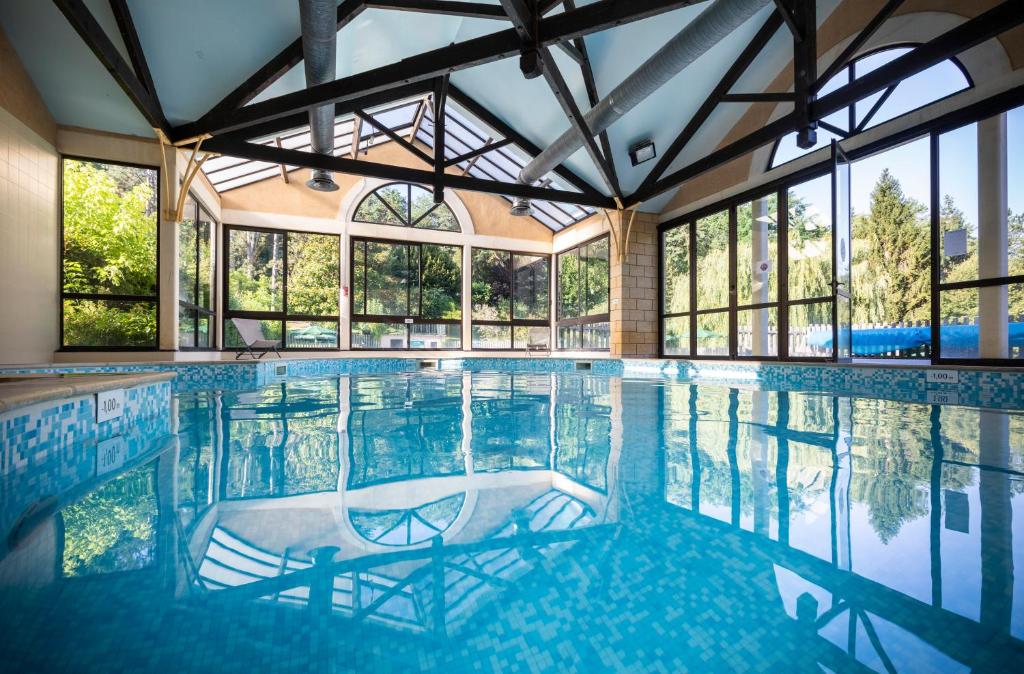 une grande piscine avec des baies vitrées dans l'établissement Les gites de Sarlat, à Sarlat-la-Canéda