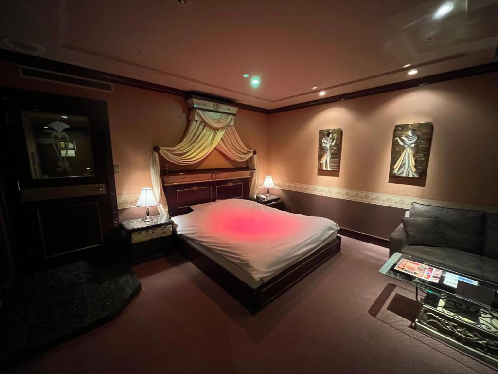 une chambre avec un grand lit et un canapé dans l'établissement Hotel Pharaoh-Adult Only, à Sapporo