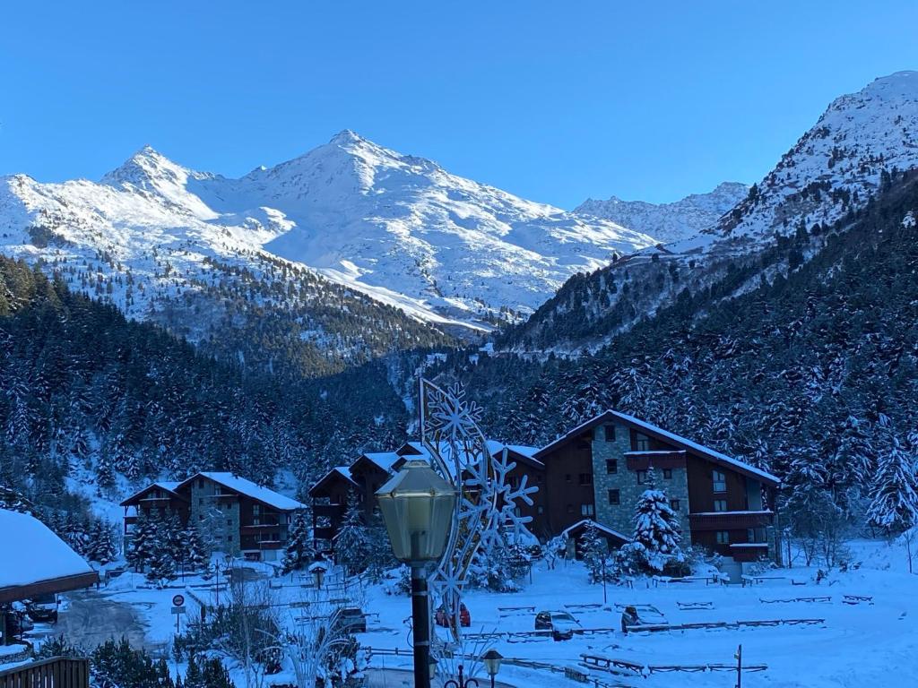 Une montagne enneigée avec des maisons et un éclairage de rue dans l'établissement Chalet Olympie, Appartement avec balcon et vue montagne, ski aux pieds, Méribel-Mottaret, à Méribel