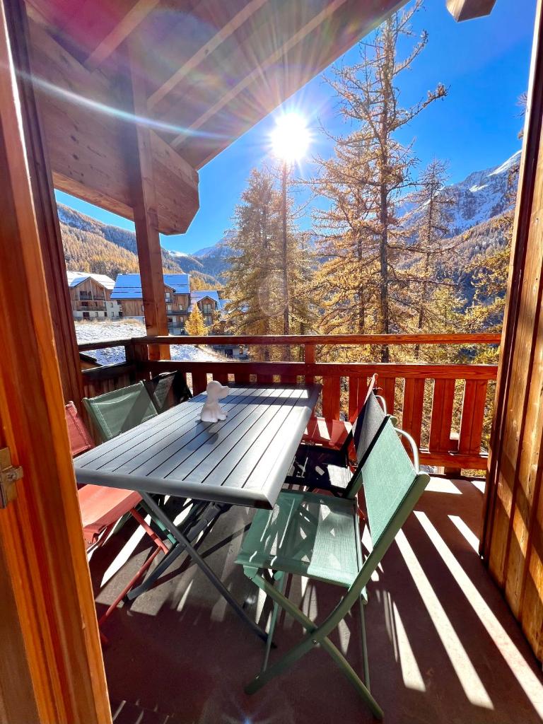 - une table de pique-nique et des chaises sur un balcon avec vue dans l'établissement CENTRE STATION 1800 - Dernier étage Rénové - 2 Chambres 6 personnes - Skis aux pieds, aux Orres