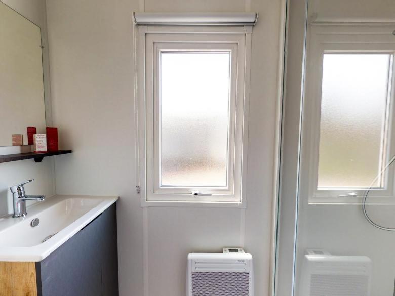 une salle de bain avec un lavabo et une fenêtre et des toilettes dans l'établissement Mobil-home 2023 RapidHome Panorama 3 chambres 6 vélos lave-vaisselle 2 piscines couvertes, à Litteau