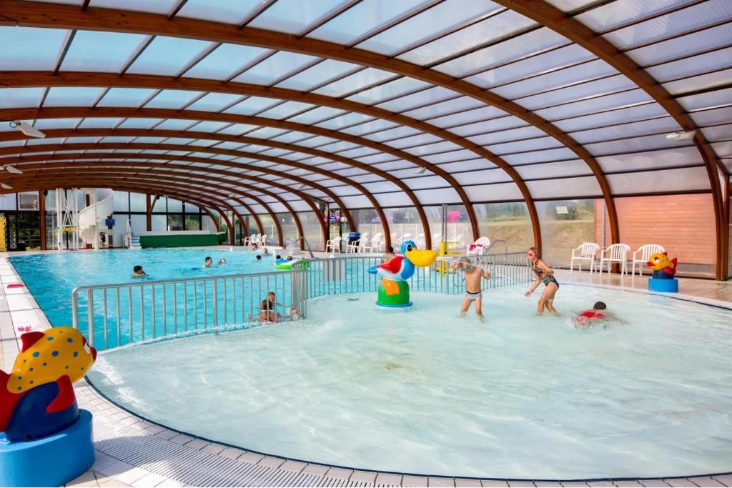 un groupe de personnes jouant dans une piscine intérieure dans l'établissement Mobil-home 2023 RapidHome Panorama 3 chambres 6 vélos lave-vaisselle 2 piscines couvertes, à Litteau