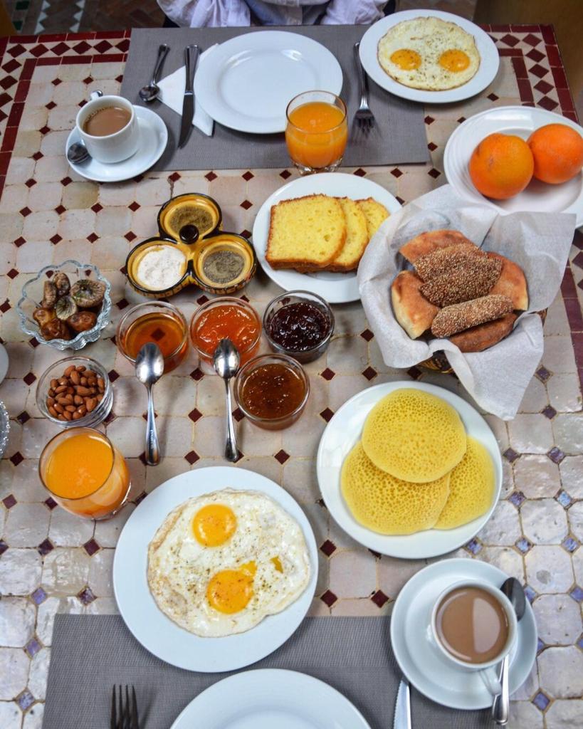 - une table avec des assiettes de produits pour le petit-déjeuner et du café dans l'établissement Dar Miouda Fes, à Fès