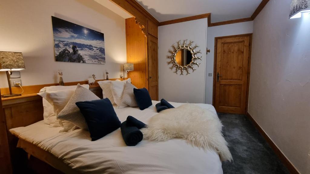 une chambre avec un lit avec des oreillers noirs et blancs dans l'établissement Arc 1950 Appartement de standing Refuge du Montagnard, vue incroyable sur le Montblanc, skis aux pieds Accès spa et piscine, à Arc 1950 29 autres photos