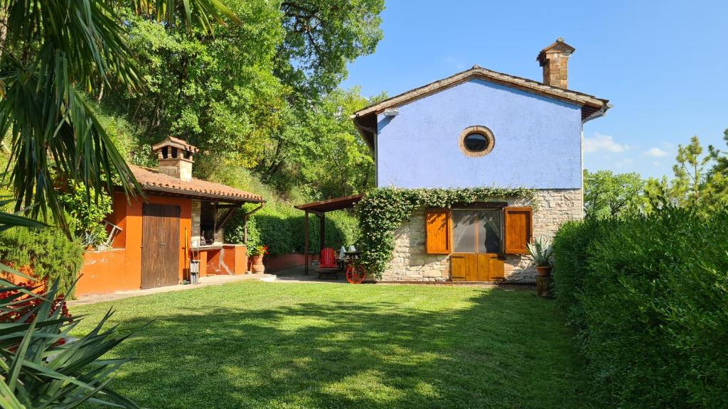 une petite maison avec une cour verdoyante devant elle dans l'établissement villa la chiesetta - private pool - Borgo Canapegna, à Fabriano