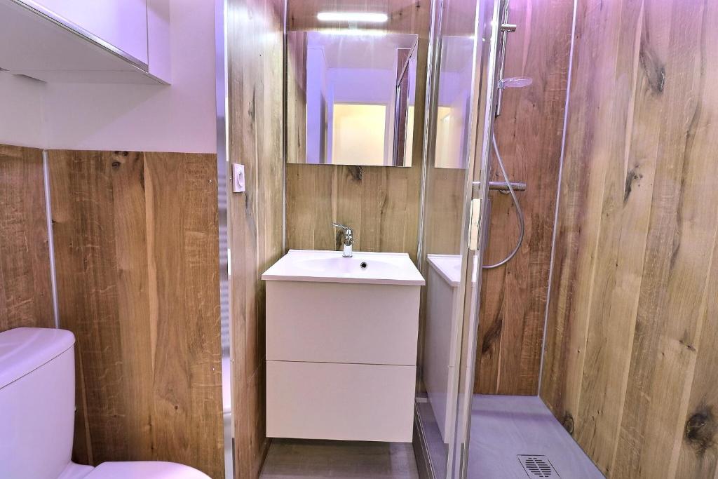 une salle de bain avec un lavabo blanc et une douche dans l'établissement Residence Pralin, à Méribel