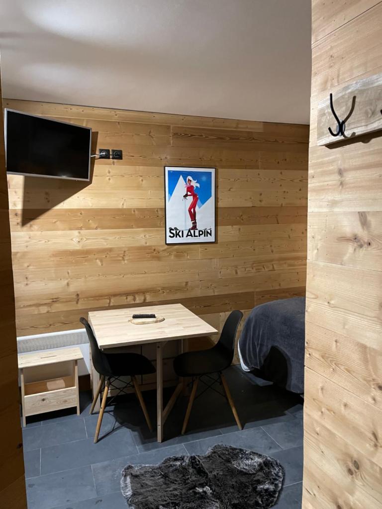 - une chambre avec une table et une télévision murale dans l'établissement Home Vars. Le studio, à Vars