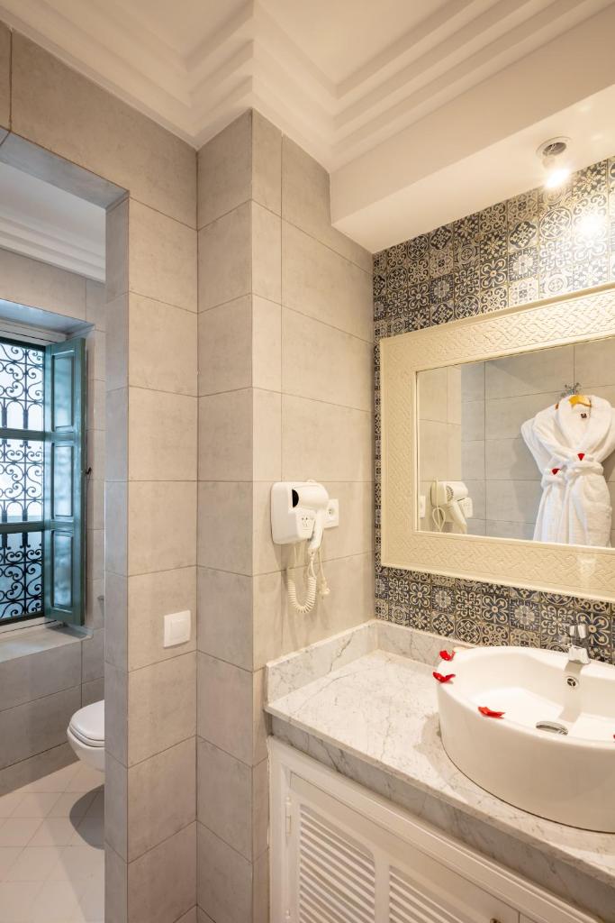 une salle de bain avec un lavabo et un miroir dans l'établissement Riad les remparts de la kasbah, à Marrakech