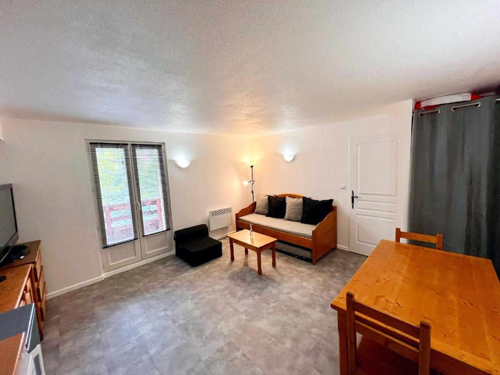 un salon avec un canapé et une table dans l'établissement Vars, Appart spacieux rénové 4 couchages dans chalet, à Vars