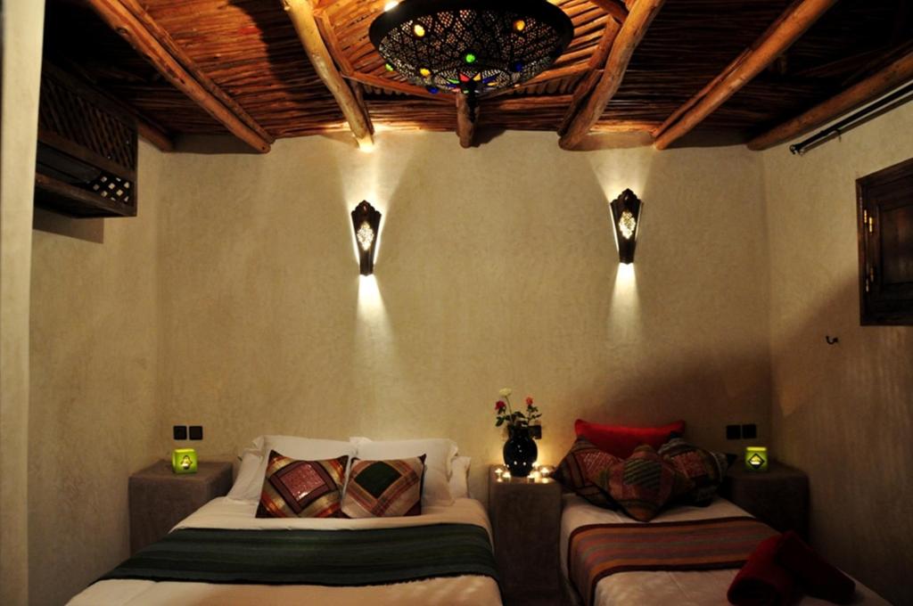 - une chambre avec deux lits et un plafond avec des lumières dans l'établissement Riad Imilchil, à Marrakech