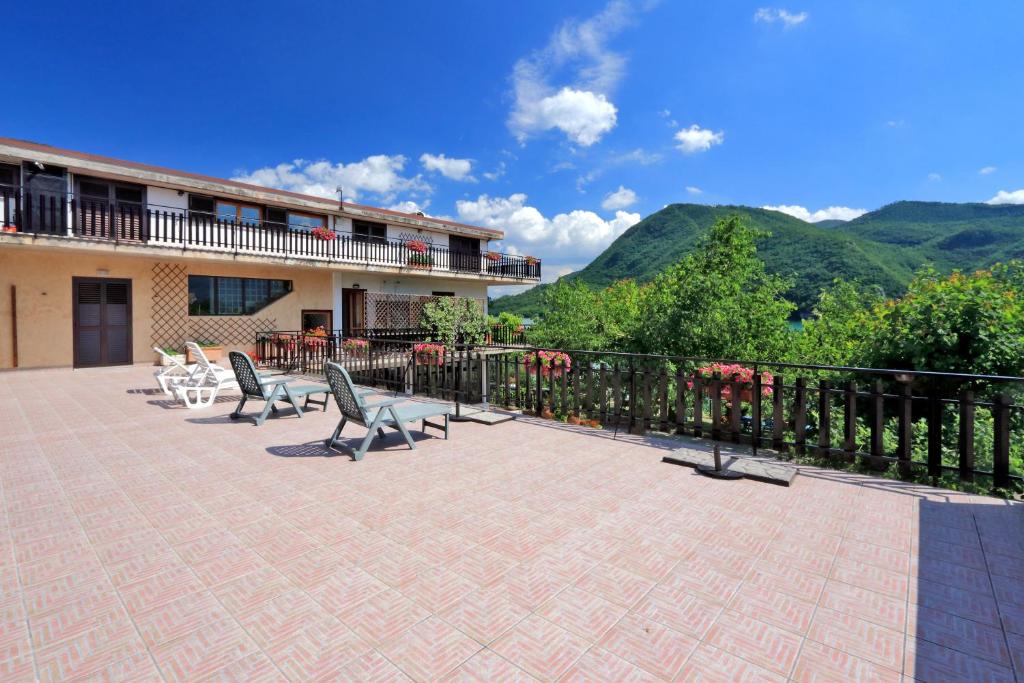 d'une terrasse avec des chaises et des tables et des montagnes en arrière-plan. dans l'établissement Hotel Turano, à Castel di Tora