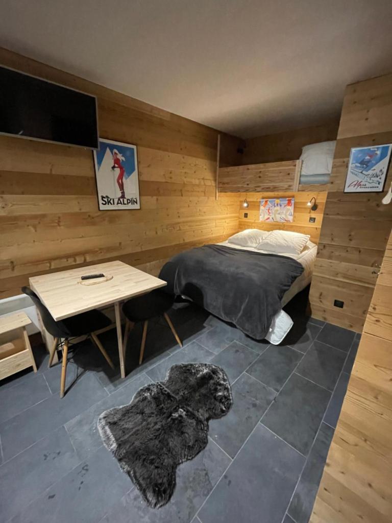 une chambre avec un lit, une table et un bureau dans l'établissement Home Vars. Le studio, à Vars